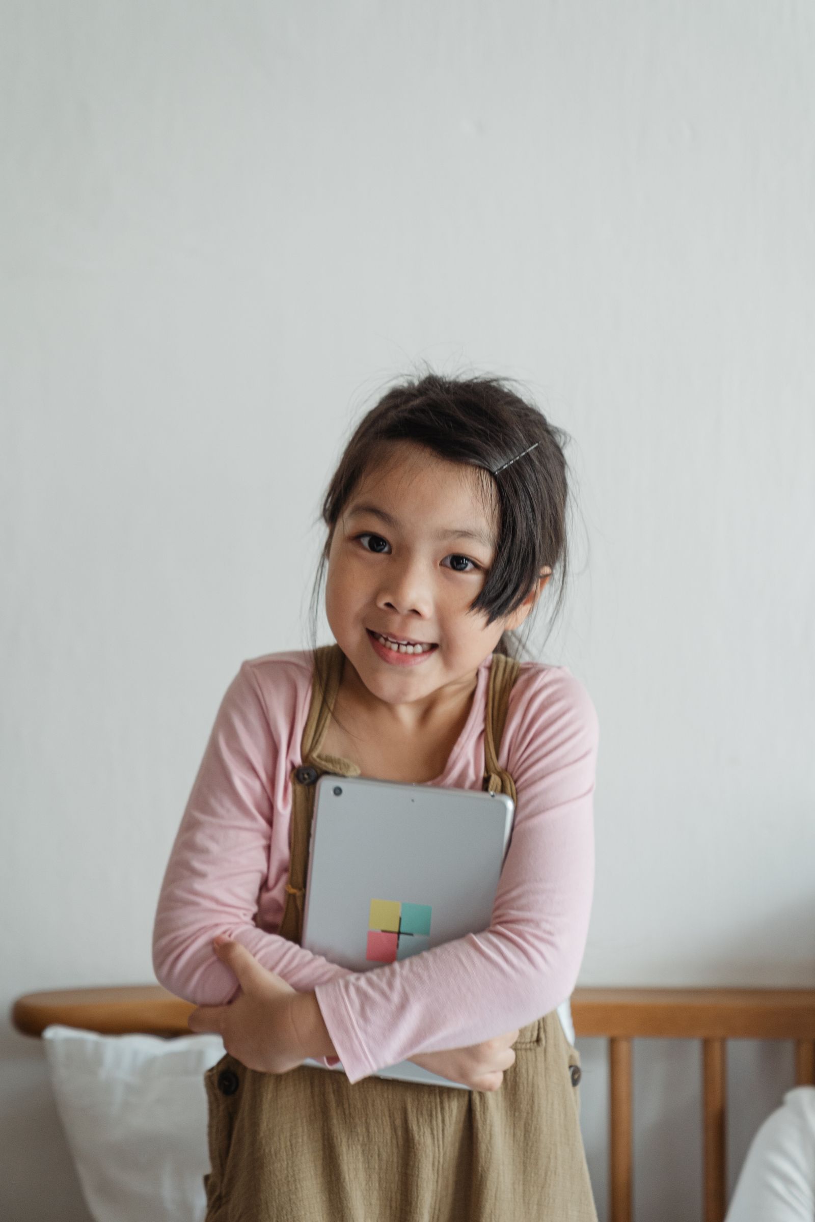 タブレットを抱える子ども(落ち着いた家庭の写真)