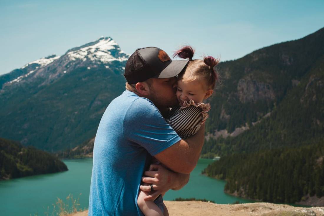 湖畔で抱き合う父親と子ども