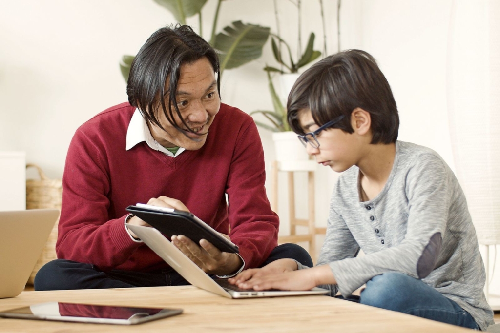 タブレットを見せながら息子に説明する父親